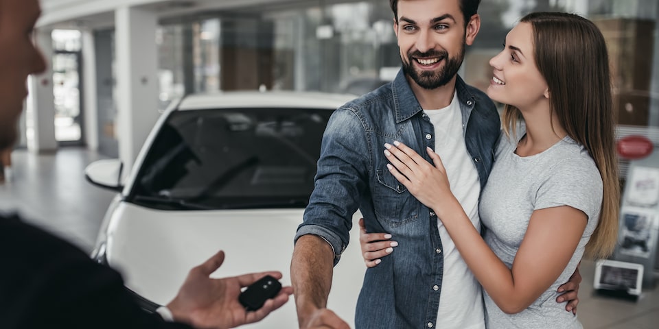 Pareja recibiendo las llaves de su vehículo seminuevo Chevrolet por el programa auto confianza